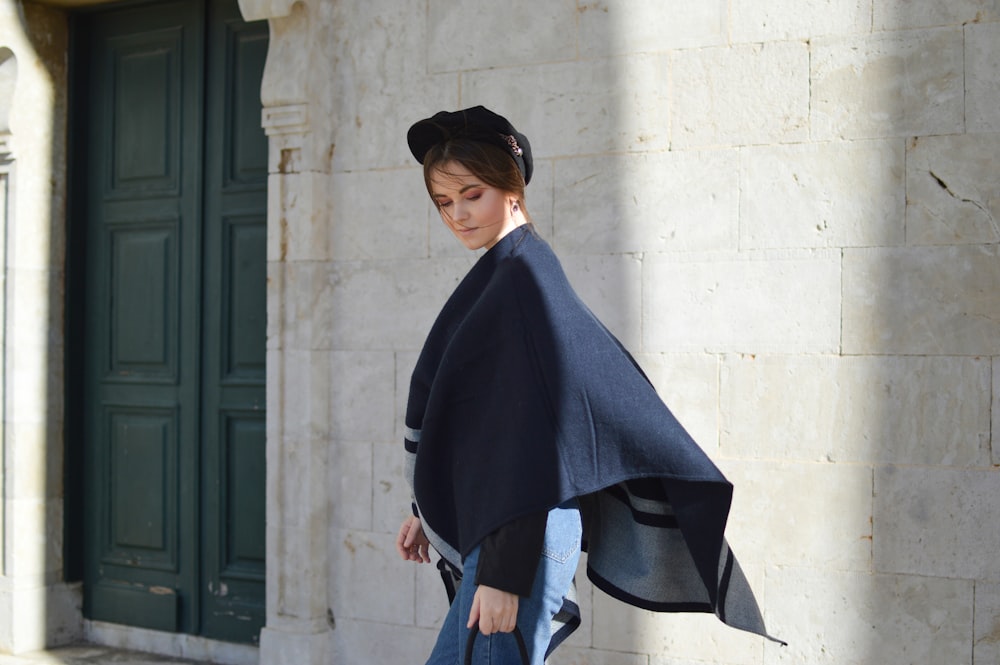 woman wear black scarf posing near wall