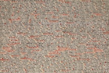 A densely packed array of names and dates, printed in various shades of black, brown, and red. The background is a pale off-white. Some of the names and dates are highlighted in red, making them stand out among the others.