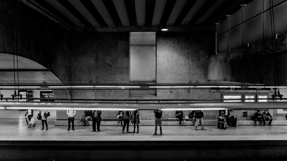 grayscale photo of people standing near building