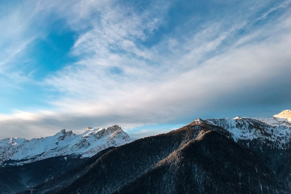 landscape photo of gray mountains covered with snow under cloudy sky during daytime