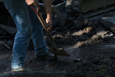 person holding brown wooden shovel