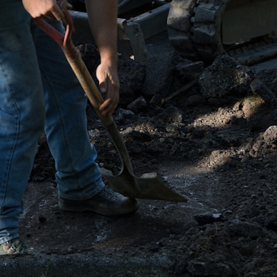 person holding brown wooden shovel