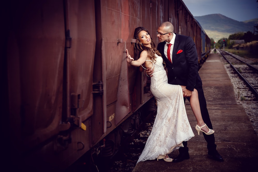bride and groom beside train during daytime