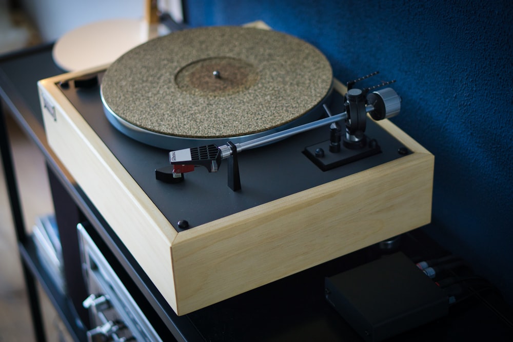 beige turntable on black wooden table