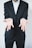 A person in a dark suit is standing with their arms extended forward, palms facing up in a gesture of openness or offering. The background is plain and light-colored, creating a sharp contrast with the dark suit.