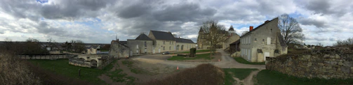 A panoramic view of a deserted village under a cloudy, dramatic sky.