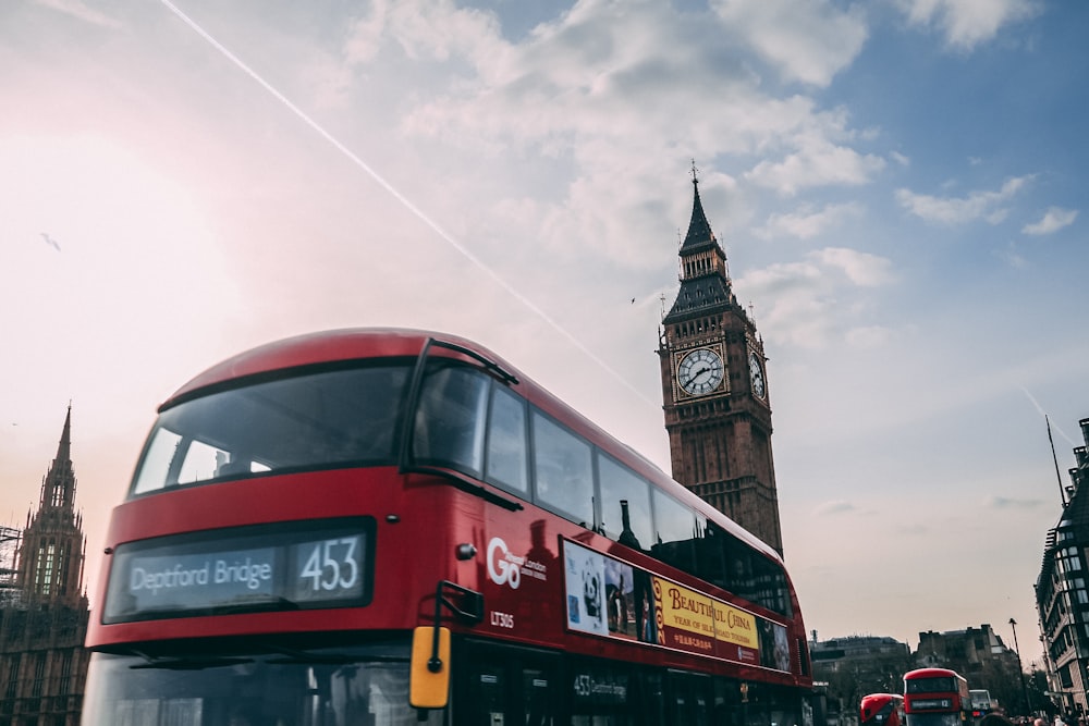 red double decker bus near brown concrete building during daytime