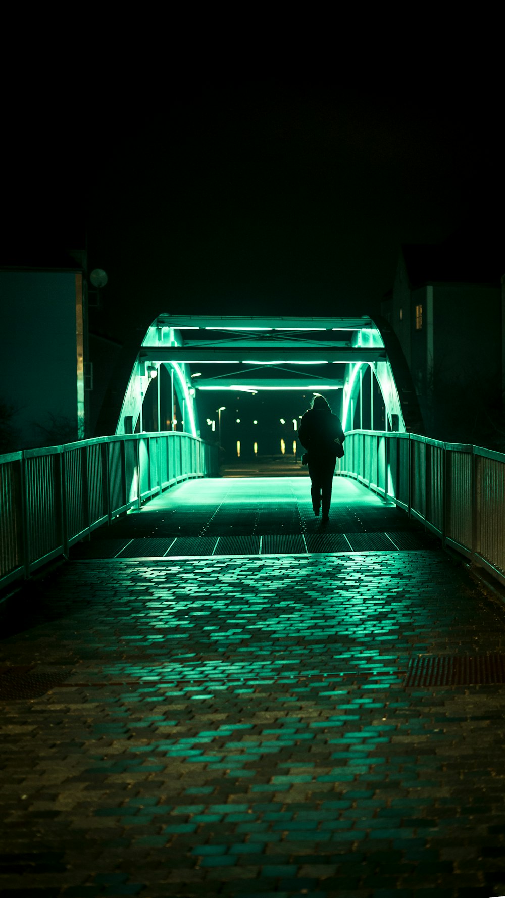 person passing alone on bridge during nighttime