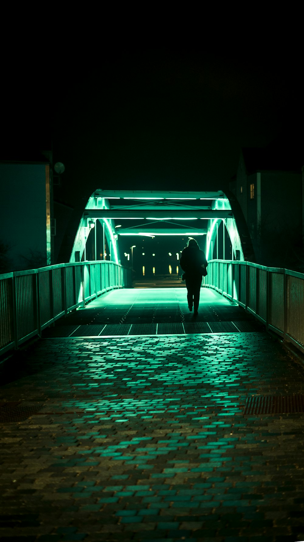 Person, die nachts allein auf der Brücke vorbeigeht