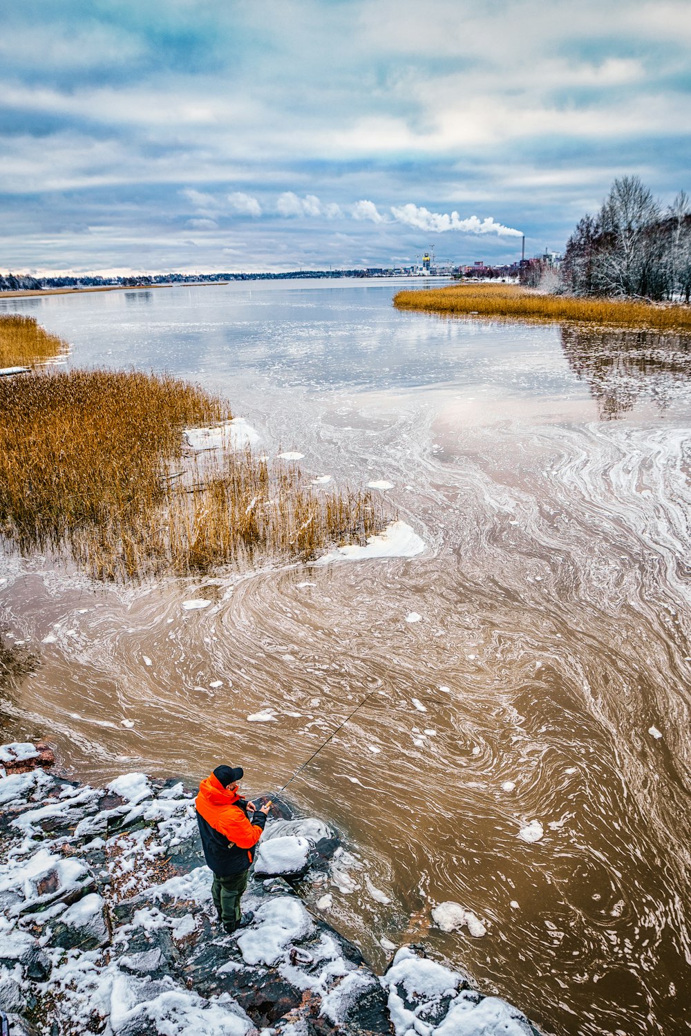 aerial photo of man fishing on body of water