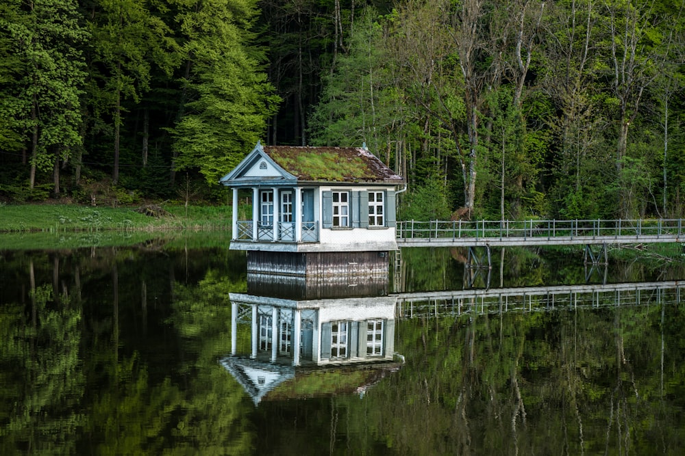 Maison blanche et verte au-dessus de l’eau