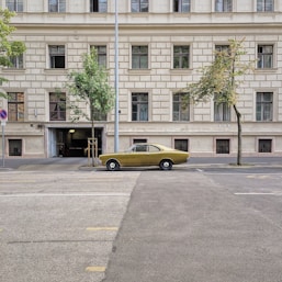 yellow sedan on concrete roadway