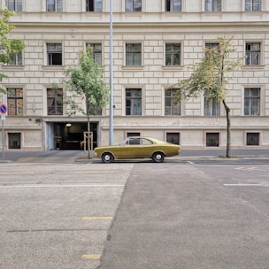 yellow sedan on concrete roadway