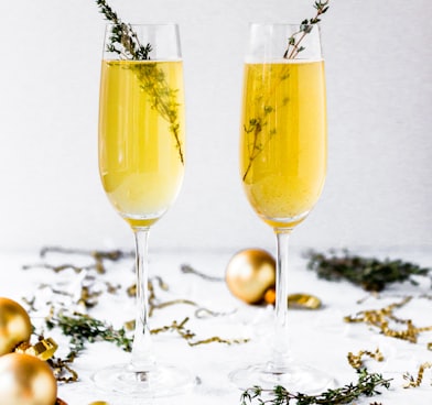 shallow focus photography of champagne glasses surrounded by gold baubles