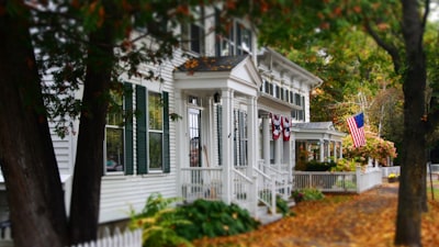 white and gray wooden house with US flag
