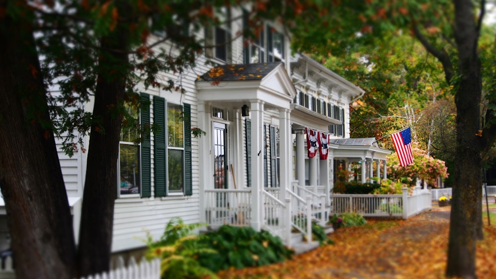 white and gray wooden house with US flag