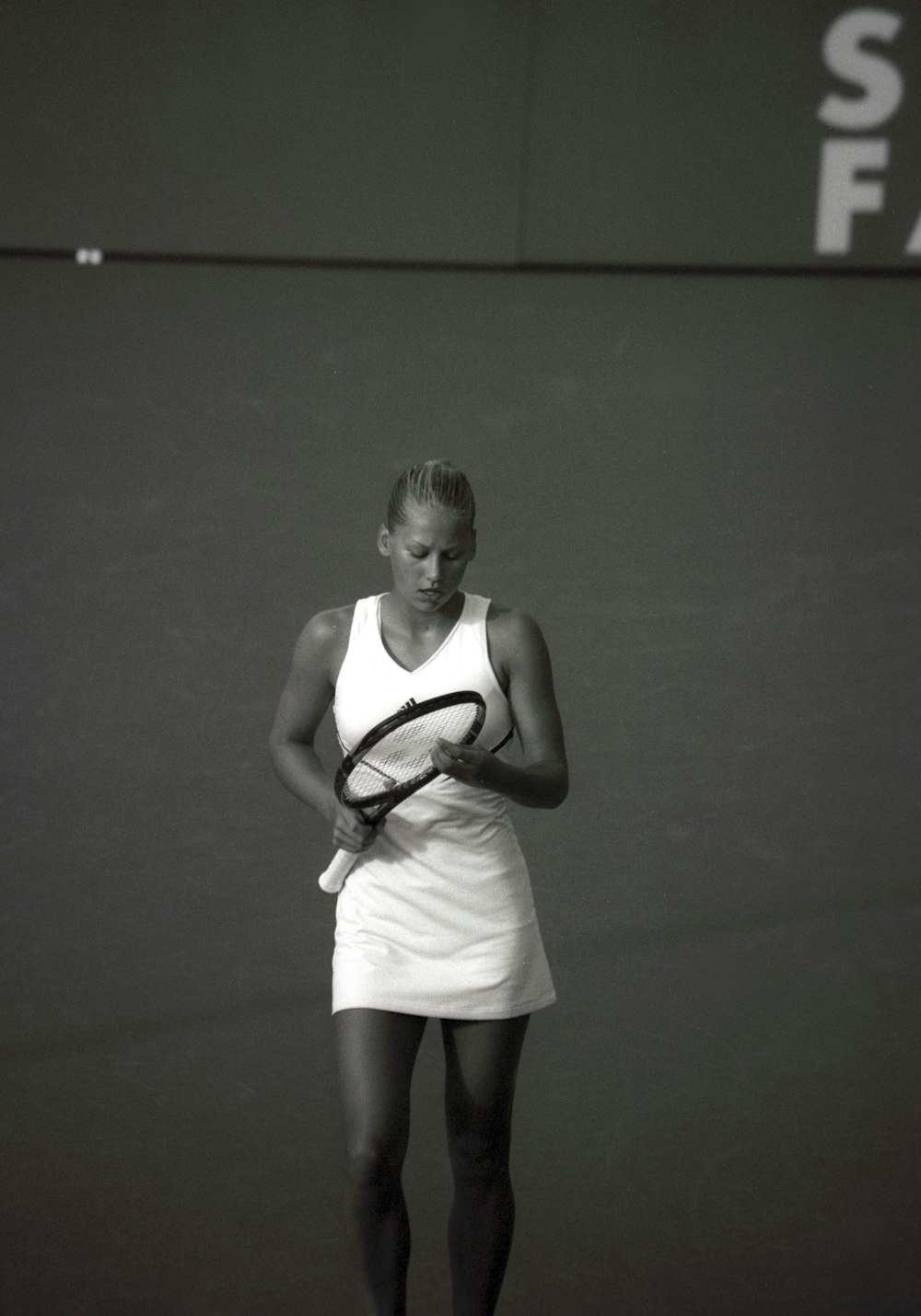mulher usando o vestido segurando a raquete do tênis