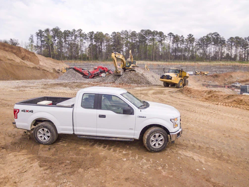 Pickup trucks and construction tools lined up ready for a day’s work at an infrastructure site.