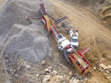 Industrial crusher machine processing rocks in the quarry.