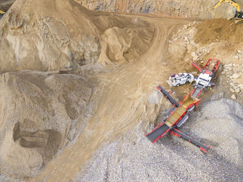 Large stone quarry with workers extracting granite blocks.