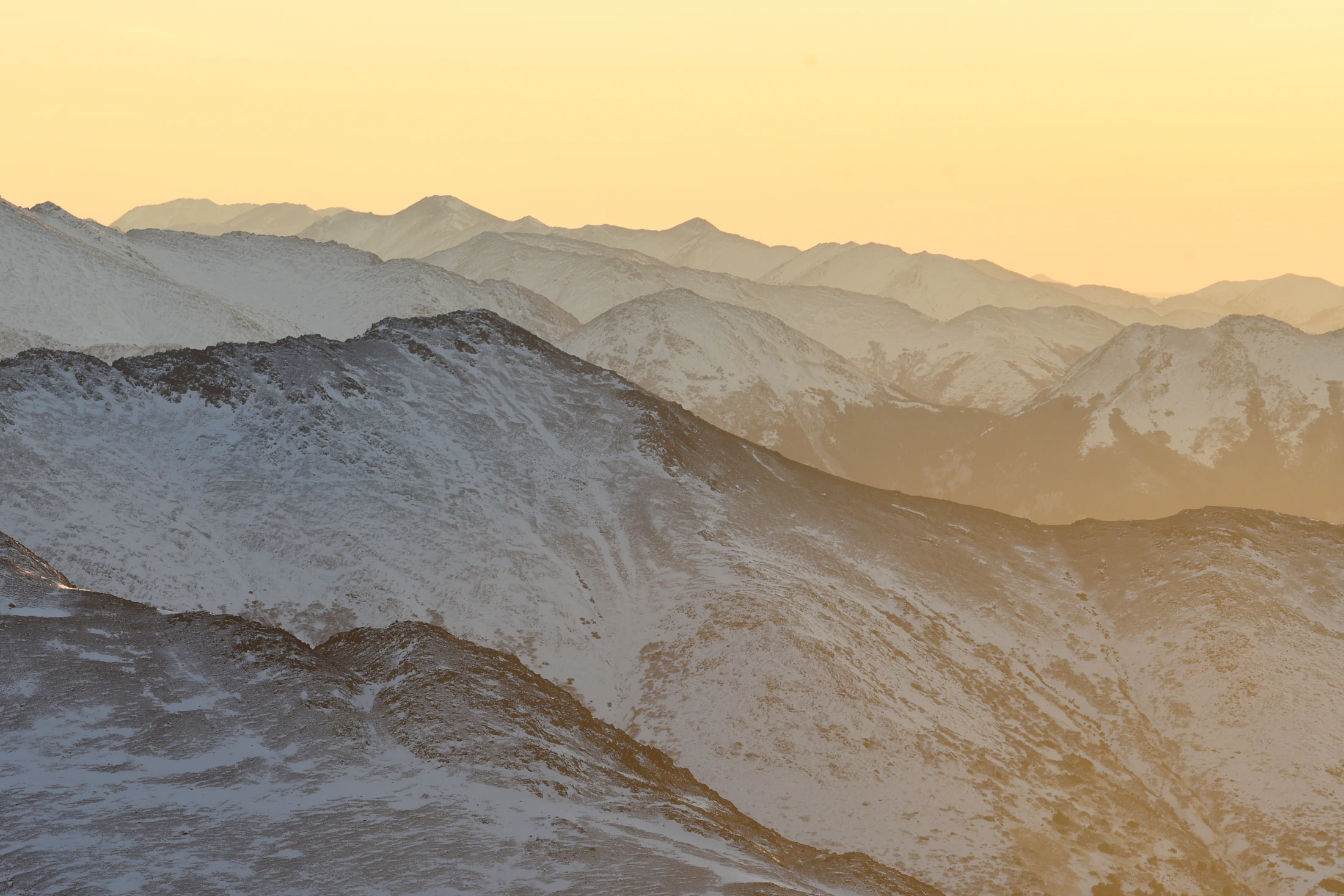 Snow-covered mountain ridges at sunset in Alaska's Chugach Mountains