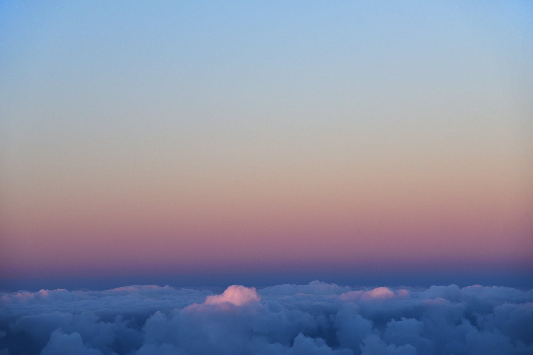 Sunrise above a sea of clouds at the summit of Haleakalā