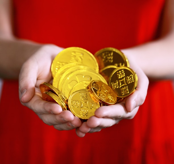 person holding gold-colored ching coins