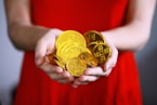 person holding gold-colored ching coins