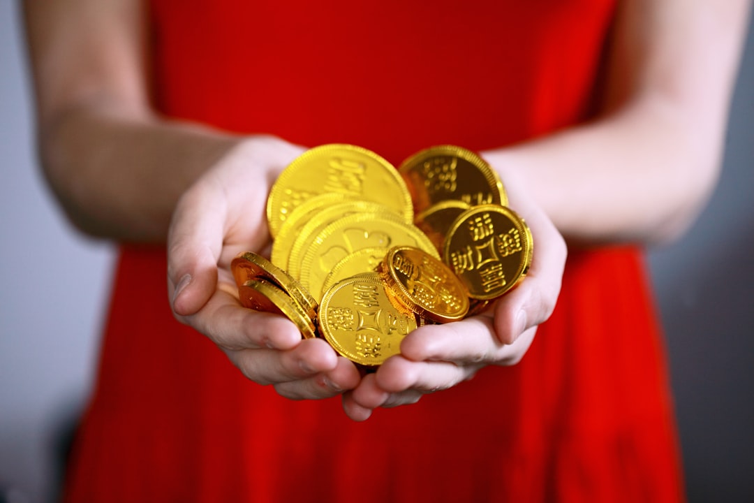 woman in red dress holding handful of gold coins