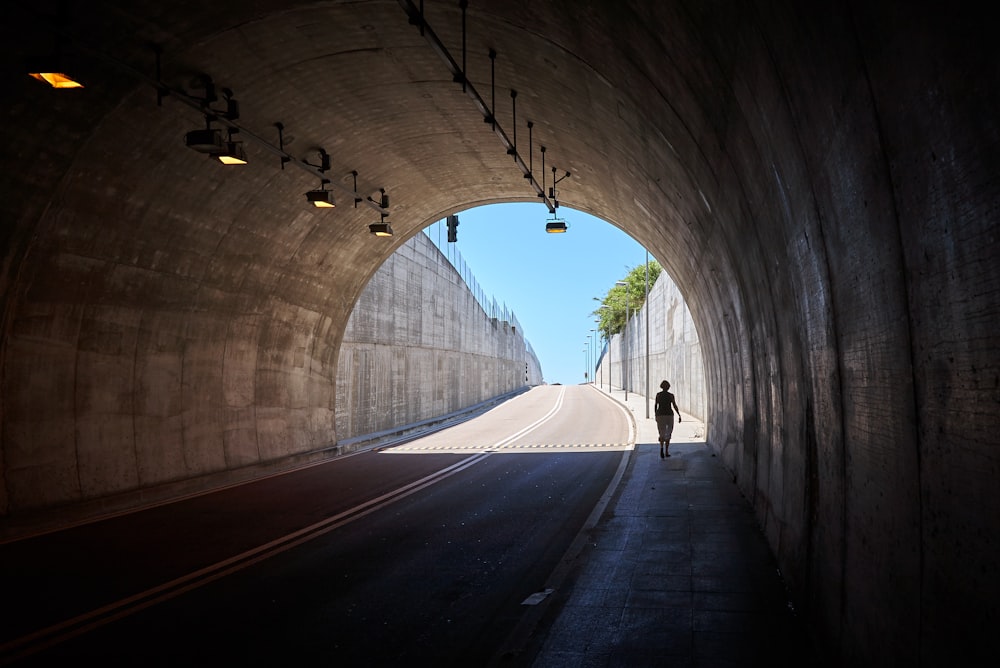 photo of person walking under tunnel