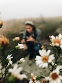 shallow focus photo of woman and flowers