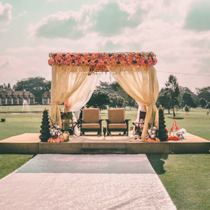 A beautifully decorated Indian wedding stage with vibrant marigold flowers and elegant drapes at an open lawn in Kanpur.