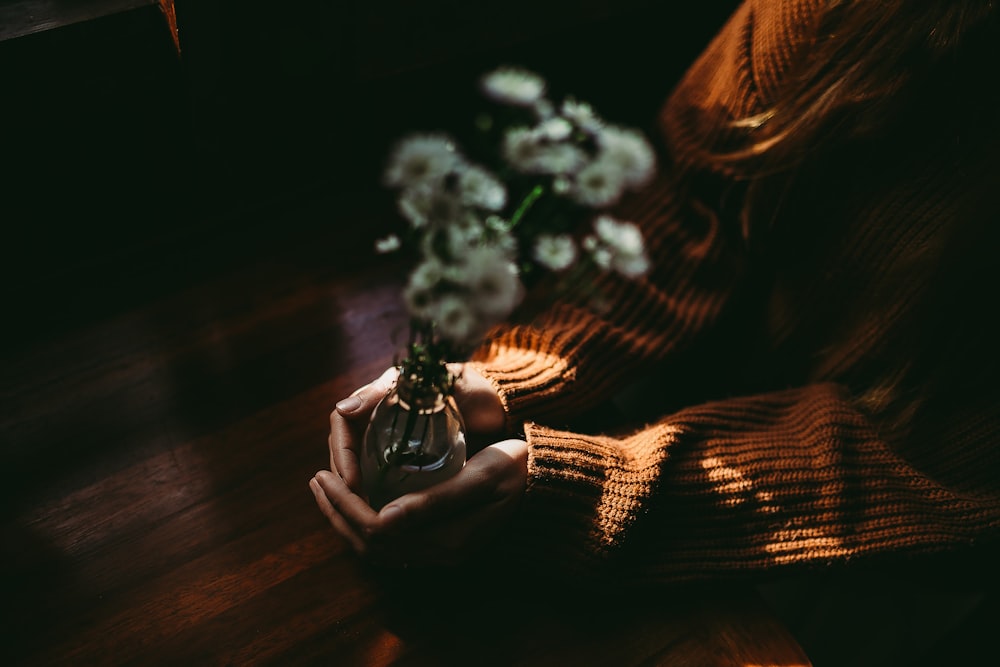 person holding clear glass vase