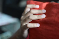 Close-up of a client’s hand resting relaxed on a treatment bed, highlighting comfort and care.