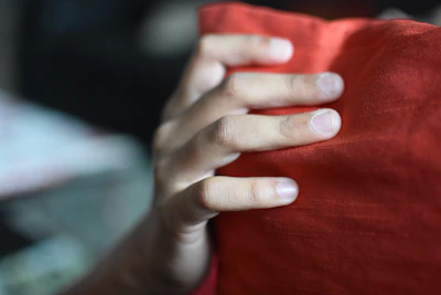 Close-up of a hand pressing down on a memory foam mattress, showing its gentle contouring and softness.