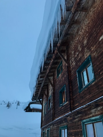 A cozy cabin in the Icelandic wilderness surrounded by snow.