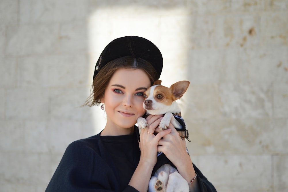portrait photo of woman carrying puppy