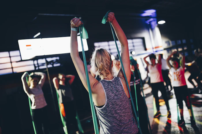 Grupo de personas entrenando piernas en una clase grupal de gimnasio