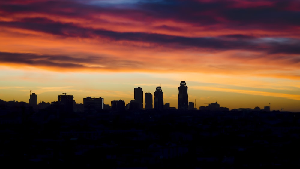 silhouette of buildings during orange sunset