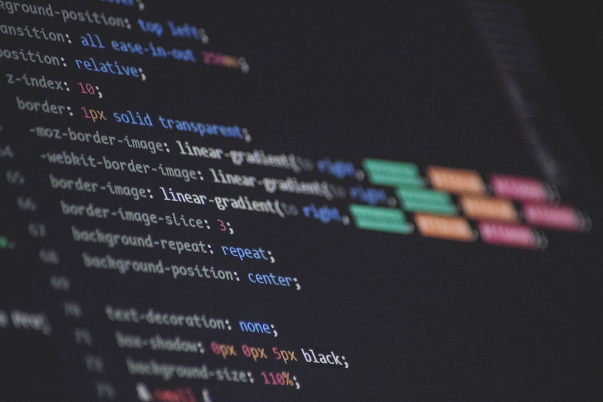 Developer reviewing custom application code on a large monitor