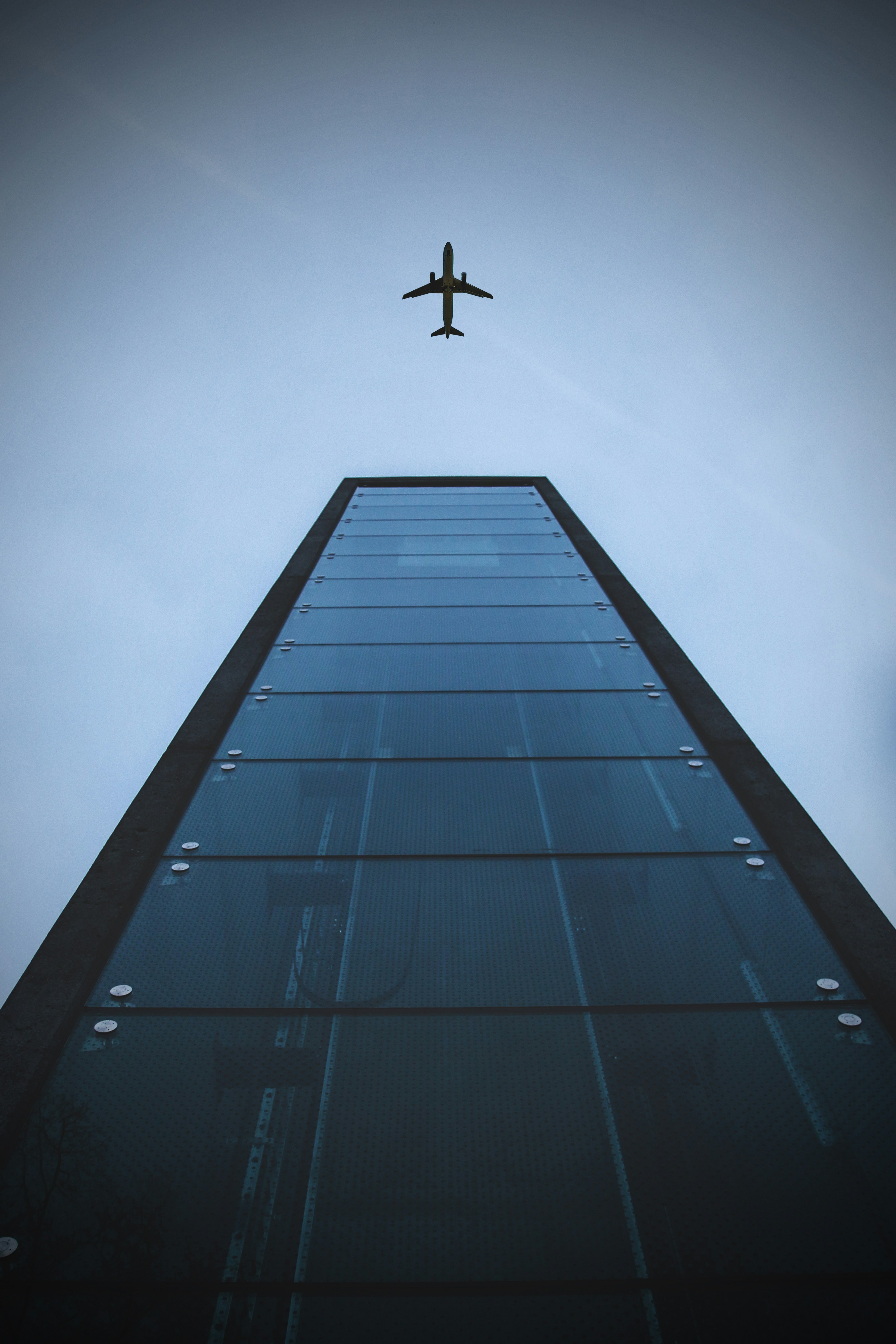 low-angle shot photography of building and airplane