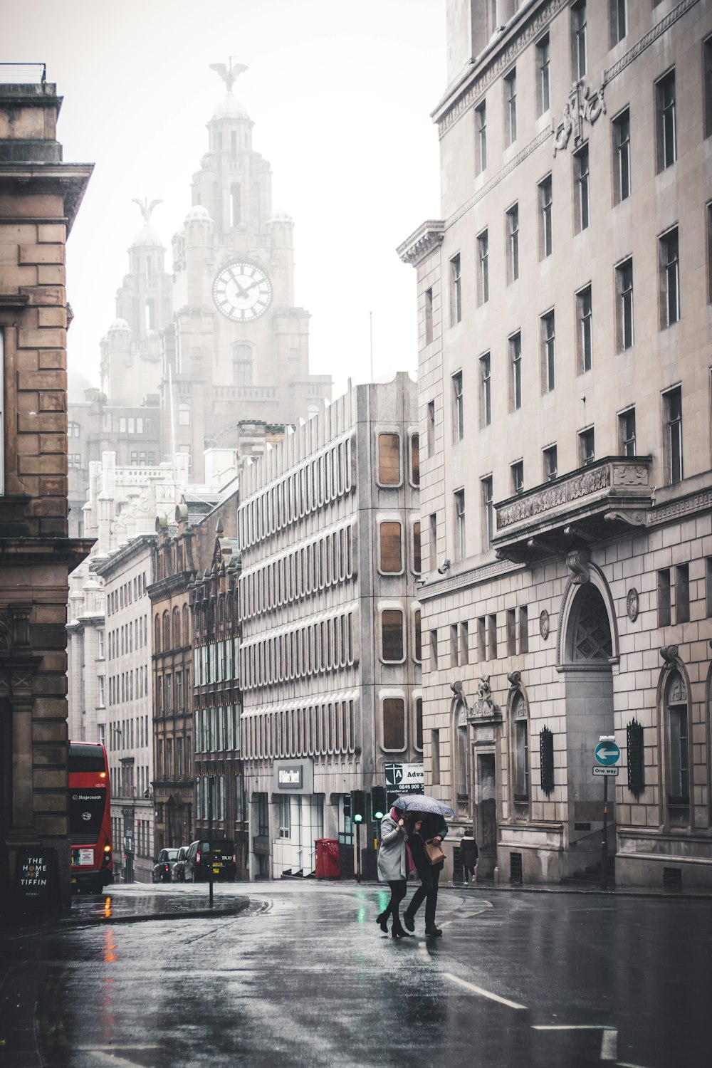 two person walking near concrete buildings