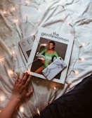 A lifestyle magazine cover displayed on a smartphone held by a person outdoors.