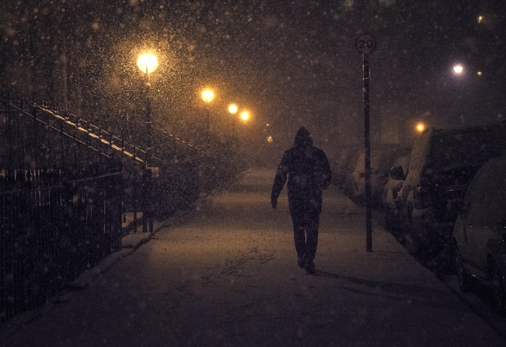 pessoa andando à noite com neve