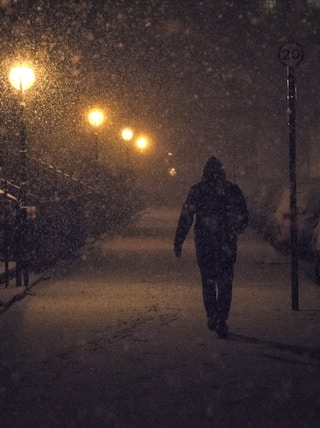person walking at night with snow
