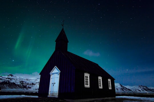 black church under northern lights at nighttime in Búðakirkja Iceland