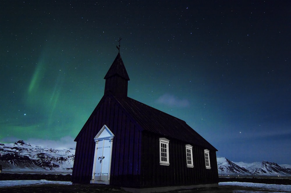 black church under northern lights at nighttime
