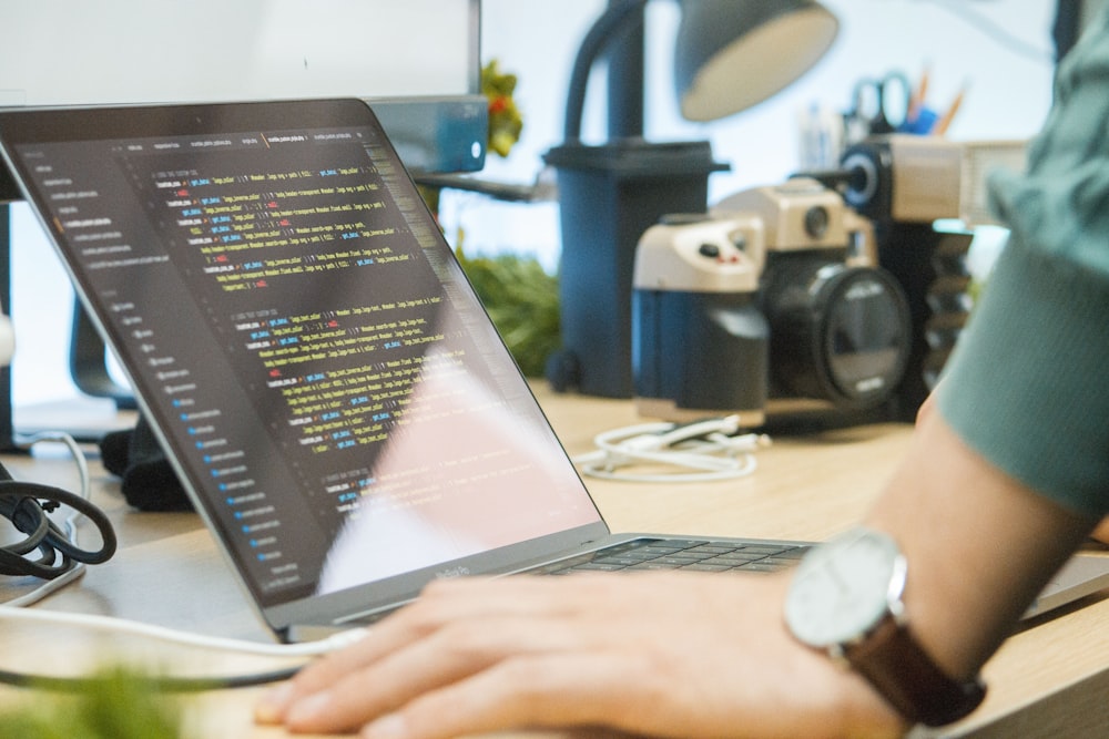 computador portátil cinzento na mesa de madeira marrom