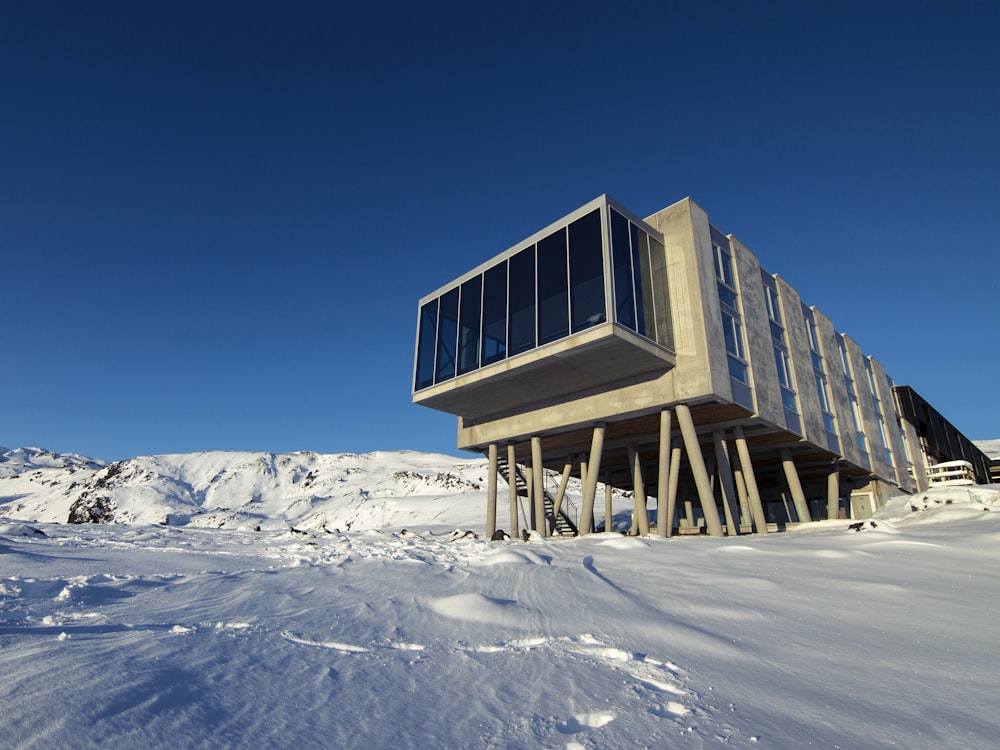rechteckige braune Holz-Organizer-Scheune auf schneebedecktem Berg während des Tages