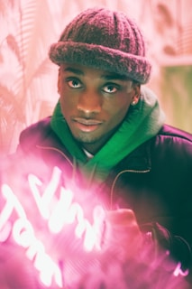 A close-up of a model wearing a boldly patterned Daily Thread hoodie under city lights